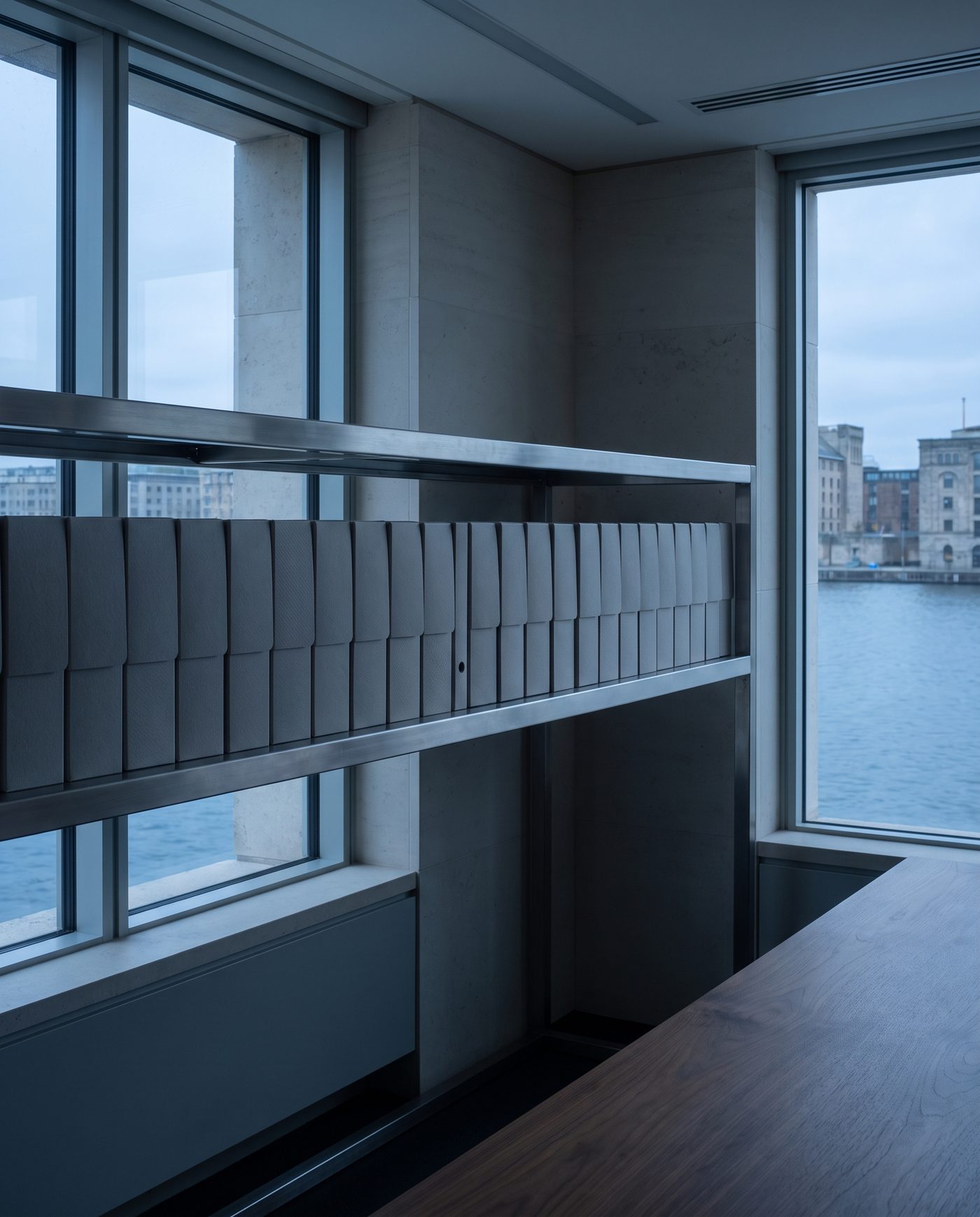 A row of identical grey employee folders on a steel shelf.