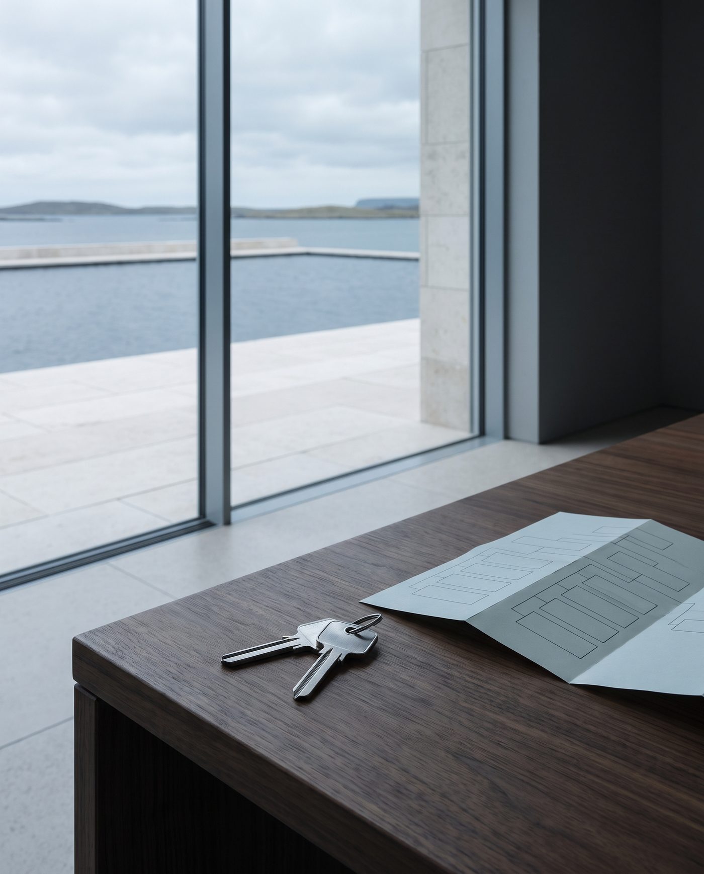 Two identical keys on a walnut desk beside a folded organisational chart.