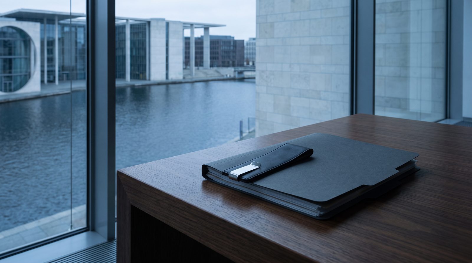 A single bookmark laid across a closed folder on walnut.